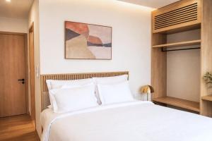 a bedroom with a large white bed and wooden cabinets at Sea La Vie Beachfront Villa - Bai Truong Beach Phu Quoc in Phú Quốc