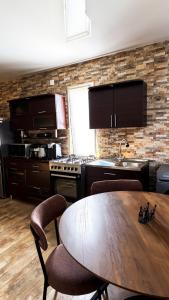 a kitchen with a wooden table with chairs and a sink at Panorama Gora in Kutaisi