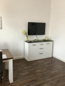a white cabinet with a flat screen tv on a wall at Ruhrpott Liebe in Herten