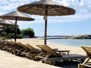 a row of chairs and umbrellas on a beach at Marina in Aghia Marina