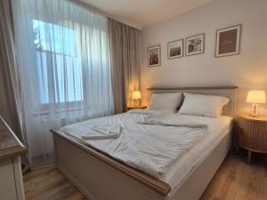 a bedroom with a bed with two lamps and a window at DORMAR I Apartament in Wałbrzych