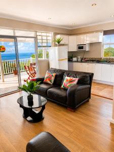 a living room with a leather couch and a table at Morne SeaView Apartments in Castries