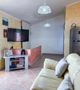 a living room with a couch and a flat screen tv at La Ginestra - Casa Vacanze in Porto Alabe
