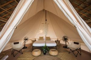 a tent with a bed and chairs in it at Glamping at Kalumo Lodge - Tent 1 in Oslob