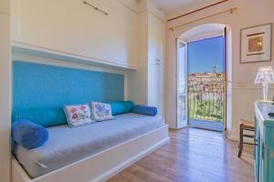a living room with a blue couch and a balcony at Apartament Vista capomare in Capoliveri