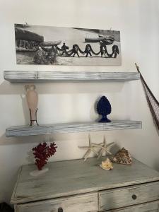 a shelf on a wall with some objects on it at Casa Ada - Incantevole loft in centro in Lampedusa
