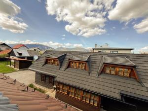 a roof of a house with mountains in the background at Drevenica u Starona in Liptovská Kokava