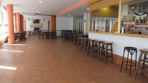 a restaurant with chairs and tables and a bar at Residencia Albergue Jaca in Jaca