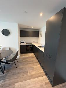 a kitchen and dining room with a table and chairs at Modern 2BD 2 bathroom apartment close to city centre in Manchester