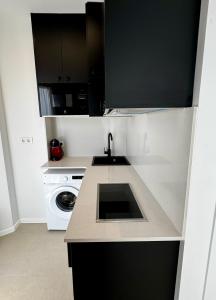 a kitchen with a sink and a washing machine at LUSAIL 1ª línea playa ADULTS ONLY in Vinarós