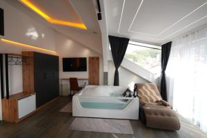a bedroom with a bed with a tub in it at Hotel Besfort in Prizren