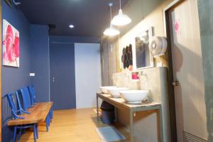 a room with three sinks and a table with blue chairs at Sleep cafe hidee247 in Pratunam
