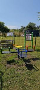 a playground with colorful play equipment in a field at Domki Amanda in Ustronie Morskie