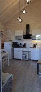 a kitchen with white appliances and a wooden ceiling at Domki Amanda in Ustronie Morskie