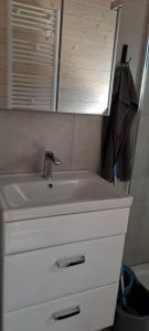 a bathroom with a white sink and a mirror at Domki Amanda in Ustronie Morskie +14 photos