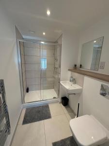 a bathroom with a shower and a toilet and a sink at Modern 2BD 2 bathroom apartment close to city centre in Manchester +4 photos