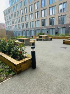 a courtyard with benches and a large building at Modern 2BD 2 bathroom apartment close to city centre in Manchester