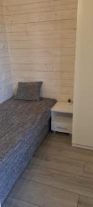 a small bedroom with a bed and a table at Domki Amanda in Ustronie Morskie