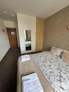a bedroom with a large bed with two towels on it at Vievija Hotel in Vievis