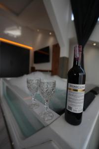 a bottle of wine and two wine glasses on a counter at Hotel Besfort in Prizren