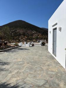a white building with a mountain in the background at Cycladic Lodge Sifnos in Apollonia
