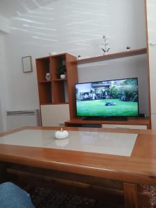 a living room with a tv and a table at Apartmani, prenoćište Ana in Tomislavgrad