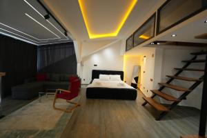 a bedroom with a bed and a staircase and a couch at Hotel Besfort in Prizren +46 photos