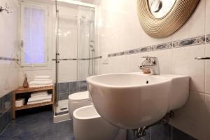 a bathroom with a sink and a toilet and a mirror at Ca' Perdon Apartment in Venice