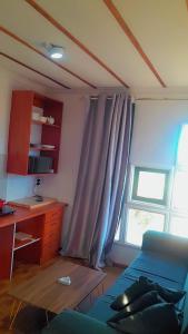 a living room with a blue couch and a desk and a window at Foodong Accommodation in Worcester