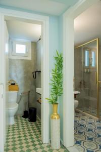 a bathroom with a toilet and a vase with a plant at Giannis Papoutsis in Posidhonía +84 photos