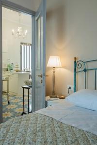a bedroom with a bed and a table with a lamp at Giannis Papoutsis in Posidhonía