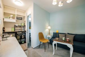 a living room with a blue couch and a table at Giannis Papoutsis in Posidhonía