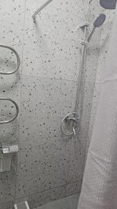 a shower with a glass door with black dots on it at Tumar in Saty