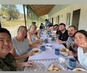 a group of people sitting at a table eating food at Tumar in Saty