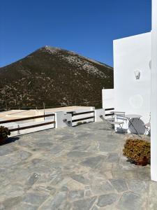a stone patio with a mountain in the background at Cycladic Lodge Sifnos in Apollonia