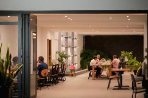 a group of people sitting at tables in a restaurant at Chez Maria Julia Boutique Hotel in Praia