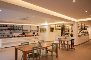 a kitchen with wooden tables and chairs and a counter at Chez Maria Julia Boutique Hotel in Praia