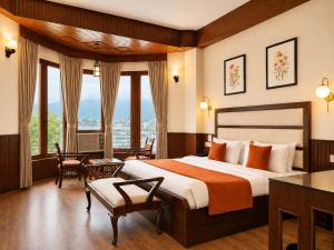 a hotel room with a bed and a large window at Shobla Royale in Kulu