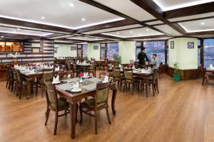 a restaurant with tables and chairs in a room at Shobla Royale in Kulu +29 photos