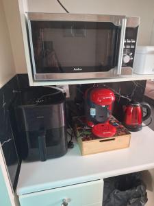a microwave sitting on top of a shelf at Noclegi 2 pokoje in Szczecinek +11 photos