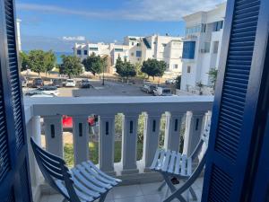 two chairs on a balcony with a view of a parking lot at Beau appt vue mer à gammarth in Gammarth