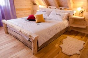 a bed in a wooden room with a wooden floor at Dolomiti Village in Comeglians