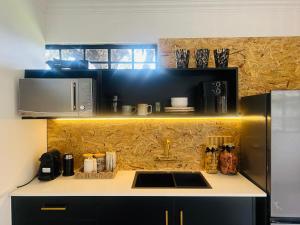 a kitchen with a sink and a microwave at Origin Cottage in eMalahleni