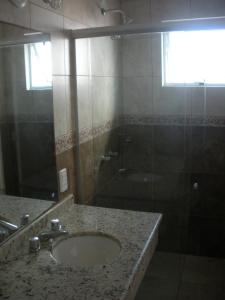 a bathroom with a sink and a shower at Fragata Azul Casa in Bombinhas