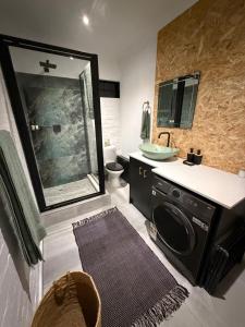 a bathroom with a sink and a washing machine at Origin Cottage in eMalahleni +11 photos