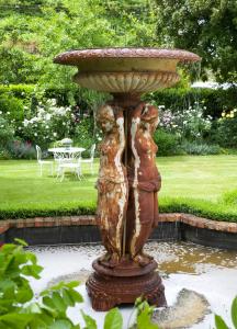 a statue of two women in a fountain in a garden at Wyett Annex in Greytown