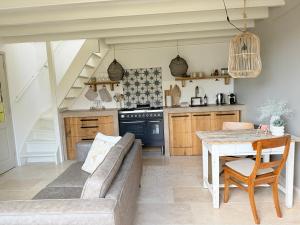 a living room with a couch and a table at Tuinderswoningen Bosrijk en Zeerijk op 100m van bos en duin in Heemskerk