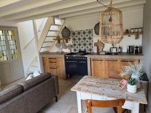 a kitchen with a couch and a table in a room at Tuinderswoningen Bosrijk en Zeerijk op 100m van bos en duin in Heemskerk +10 photos