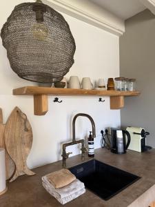 a kitchen with a sink and a faucet at Tuinderswoningen Bosrijk en Zeerijk op 100m van bos en duin in Heemskerk