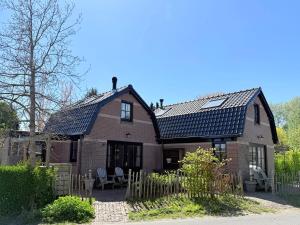 a brick house with solar panels on the roof at Tuinderswoningen Bosrijk en Zeerijk op 100m van bos en duin in Heemskerk